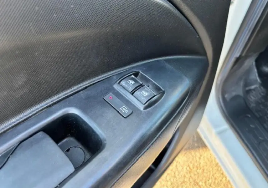 Gros plan sur le panneau de commande des vitres électriques côté conducteur d’un Opel Combo blanc de 2015.