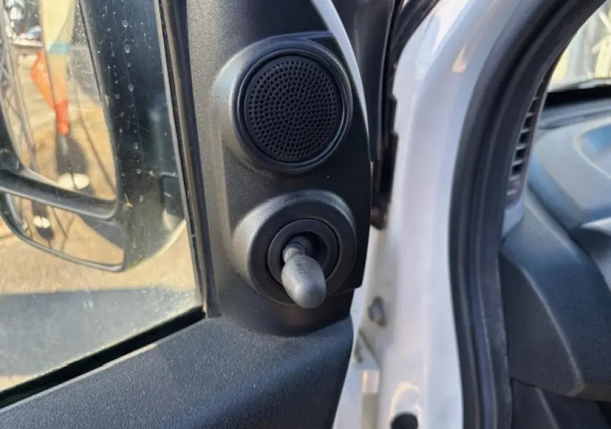 Détail du réglage manuel du rétroviseur côté conducteur sur Opel Combo blanc L1H1 2015, intérieur visible.