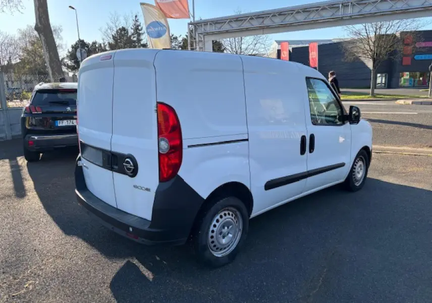 Vue 3/4 arrière droite d'un utilitaire Opel Combo blanc avec porte latérale coulissante et jantes tôle 15 pouces.