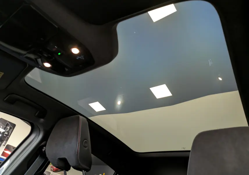 Vue intérieure du toit panoramique et des appuie-têtes avant du Renault Rafale gris Schiste, version hybride 2026.