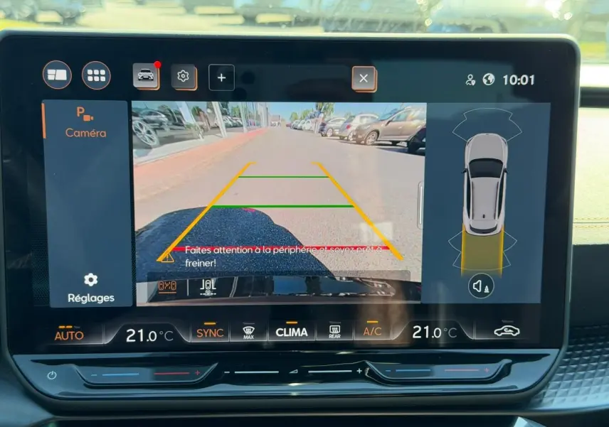 Écran tactile intérieur montrant la caméra de recul active avec vue arrière et alertes de proximité du CUPRA Formentor gris métallisé.