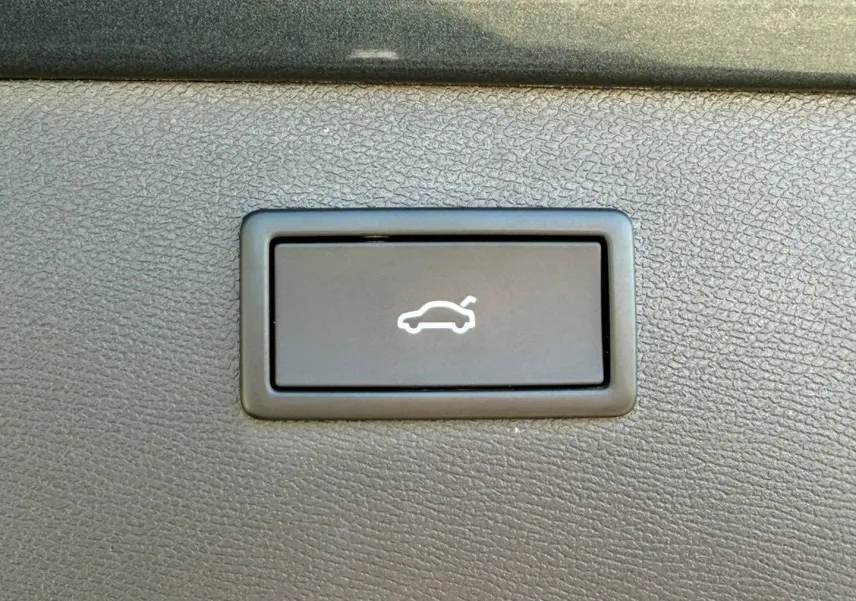 Bouton d'ouverture électrique du coffre sur tableau de bord noir texturé d'un CUPRA Formentor gris métallisé 2025.