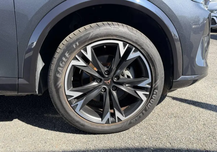 Gros plan sur la roue avant droite du CUPRA Formentor gris Magnétique, jante alu noire et argentée au design sportif.