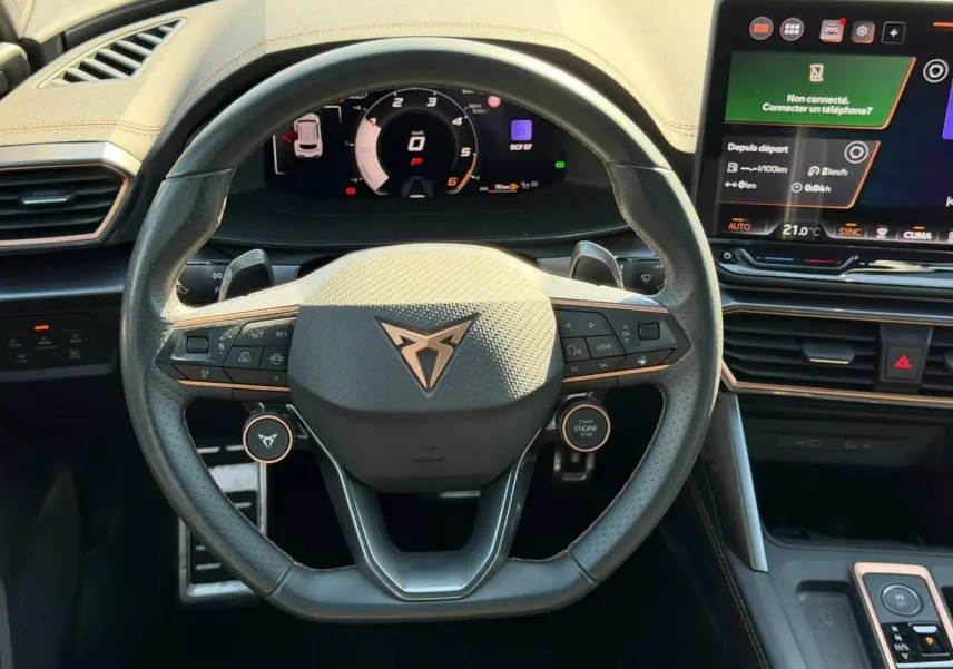 Vue intérieure centrée sur le volant sport CUPRA Formentor 2025 avec commandes multifonctions et écran tactile à droite.