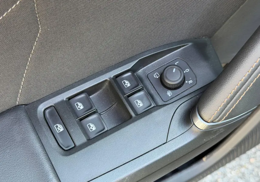 Gros plan sur les commandes des vitres et rétroviseurs côté conducteur d’une CUPRA Formentor gris Magnétique.