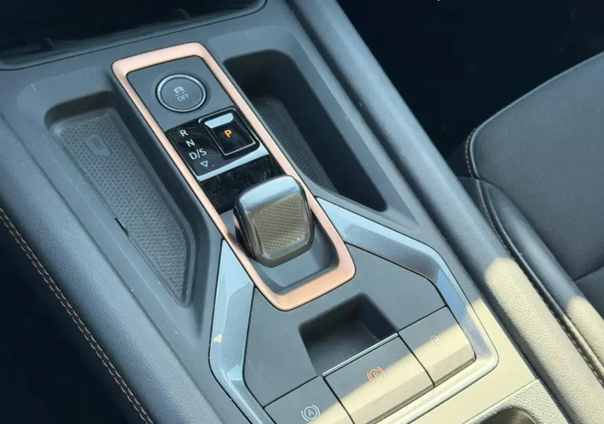 Vue rapprochée de la console centrale noire avec levier de vitesse automatique et surpiqûres cuivre du CUPRA Formentor 2025.