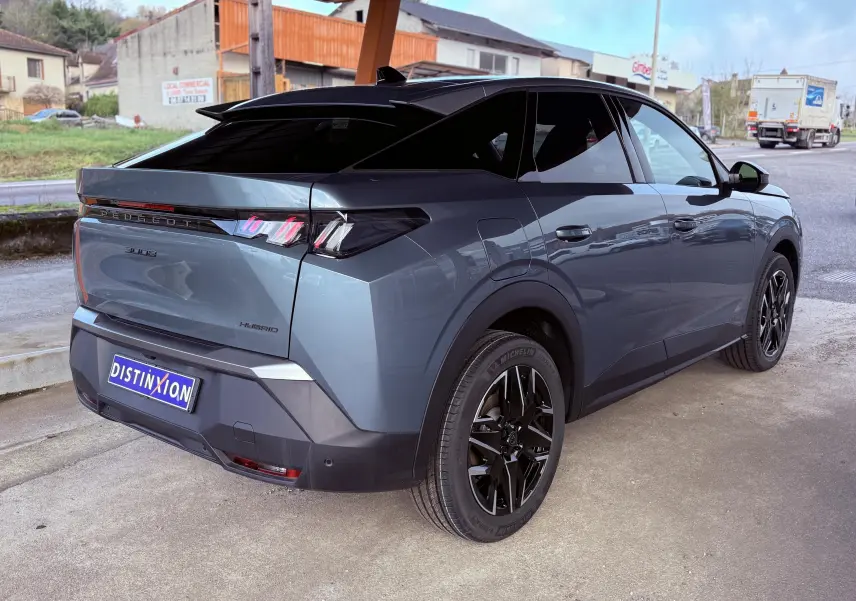 Vue 3/4 arrière droite du Peugeot 3008 Hybrid 136ch Allure en bleu Ingaro métal avec jantes noires et toit noir contrasté.