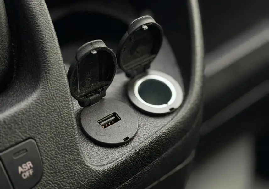 Gros plan sur les ports USB et prise 12V intégrés dans l’habitacle noir du fourgon Opel Movano L1H1.