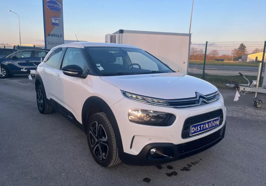 Citroën C4 Cactus blanc vue 3/4 avant droit, avec protections noires et jantes alliage distinctives.