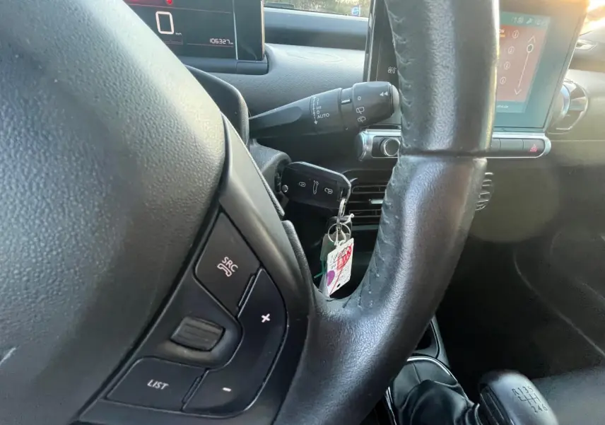 Gros plan sur le volant noir de la Citroën C4 Cactus 2020 avec commandes au volant et levier de vitesse manuel visible.