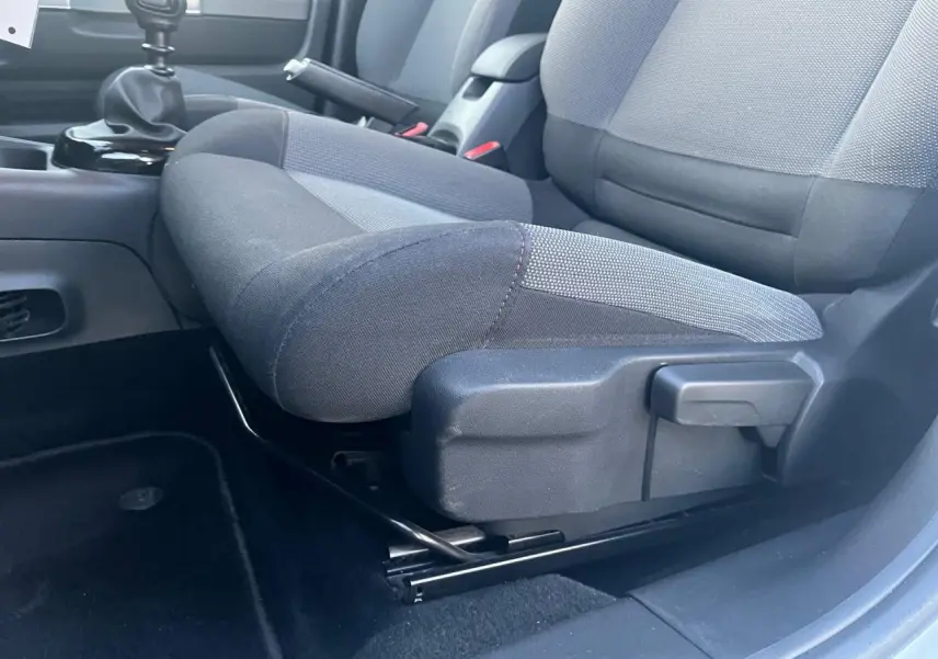 Gros plan sur le siège avant gauche et levier de vitesse manuel d'une Citroën C4 Cactus 2020 blanche, intérieur tissu gris.
