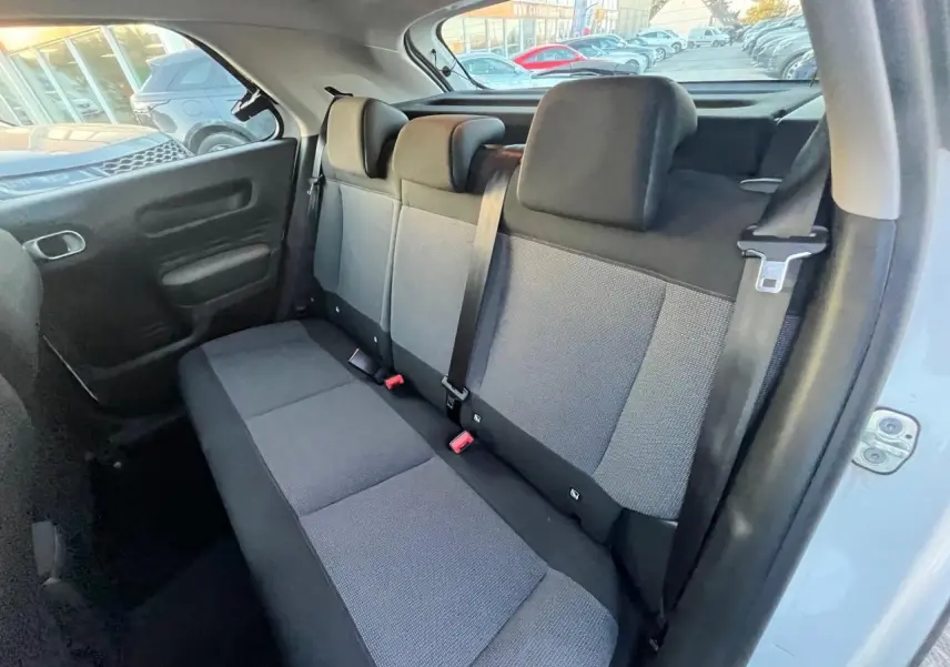Vue intérieure côté arrière droit montrant la banquette arrière grise du Citroën C4 Cactus blanc de 2020.
