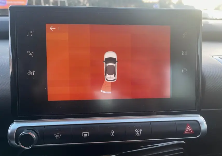 Écran tactile central du Citroën C4 Cactus 2020 montrant l'aide au stationnement avec vue schématique du véhicule blanc.
