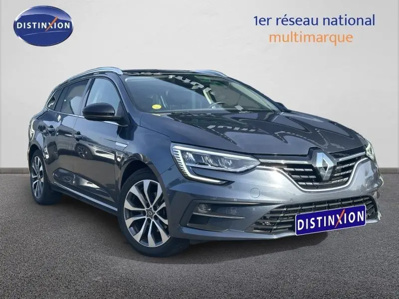 Renault Mégane Break gris titanium vue 3/4 avant droit avec jantes alu et calandre chromée visible.