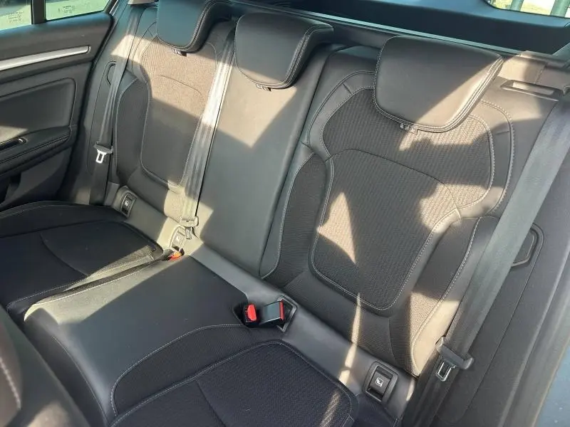 Vue intérieure de la banquette arrière noire de la Renault Mégane Break 2024, avec ceintures et appuie-têtes visibles.