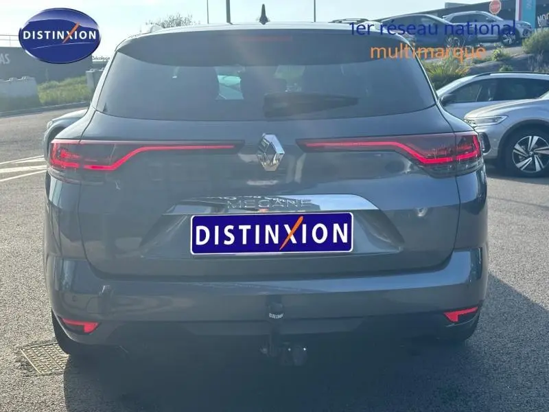 Vue arrière d'une Renault Mégane Break gris titanium 2024 avec feux LED et attelage visible en extérieur.