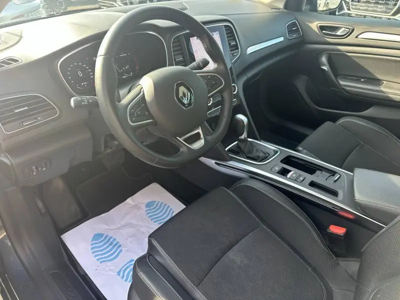 Intérieur noir de la Renault Mégane Break 2024, vue côté conducteur sur volant multifonction et console centrale.