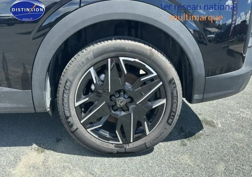 Gros plan sur la roue arrière droite noire du Peugeot 5008 Hybrid 145 allure e-dcs6 2025 avec jante alu distinctive.