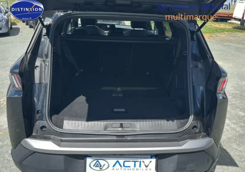 Coffre ouvert vu de l'arrière d'un Peugeot 5008 Hybrid 145 allure e-dcs6 noir avec banquette rabattue.