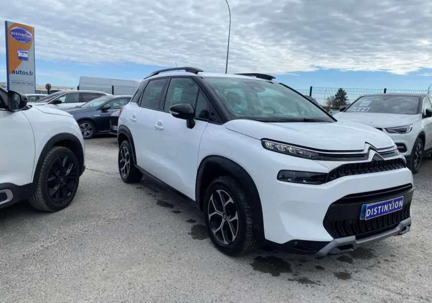 Citroën C3 Aircross blanc 2023 en 3/4 avant droit, avec toit noir et jantes alliage distinctives.