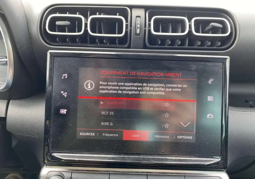 Vue rapprochée de la console centrale du Citroën C3 Aircross blanc 2023, écran tactile avec message d'absence de navigation.