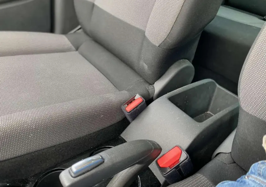 Gros plan sur les sièges avant et la console centrale du Citroën C3 Aircross 2023, avec ceintures rouges visibles.