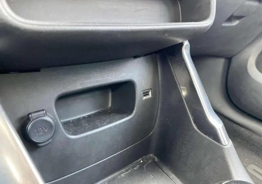 Détail de la console centrale côté passager du Citroën C3 Aircross blanc 2023 avec prise 12V et port USB visible.