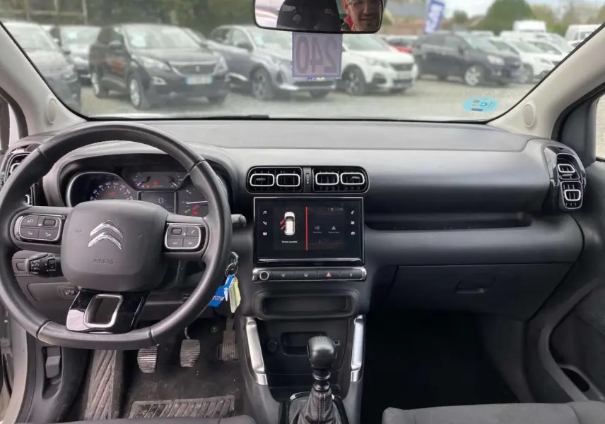 Vue intérieure du tableau de bord et volant du Citroën C3 Aircross blanc 2023, version diesel manuelle Shine.