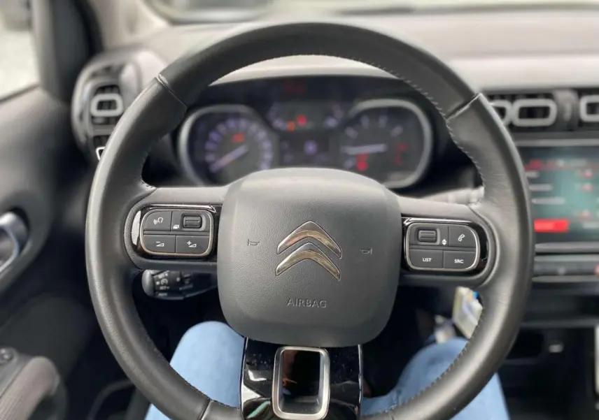 Vue centrée du volant noir avec commandes intégrées du Citroën C3 Aircross 2023, version Shine diesel.