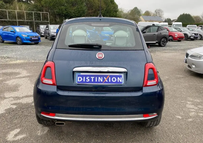 Vue arrière d'une FIAT 500 bleu foncé 2019 avec toit panoramique, stationnée sur un parking extérieur.
