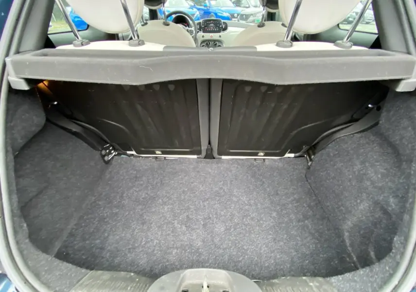 Coffre ouvert d'une Fiat 500 2019 couleur INC, vue intérieure arrière montrant l'habitacle et les sièges avant.