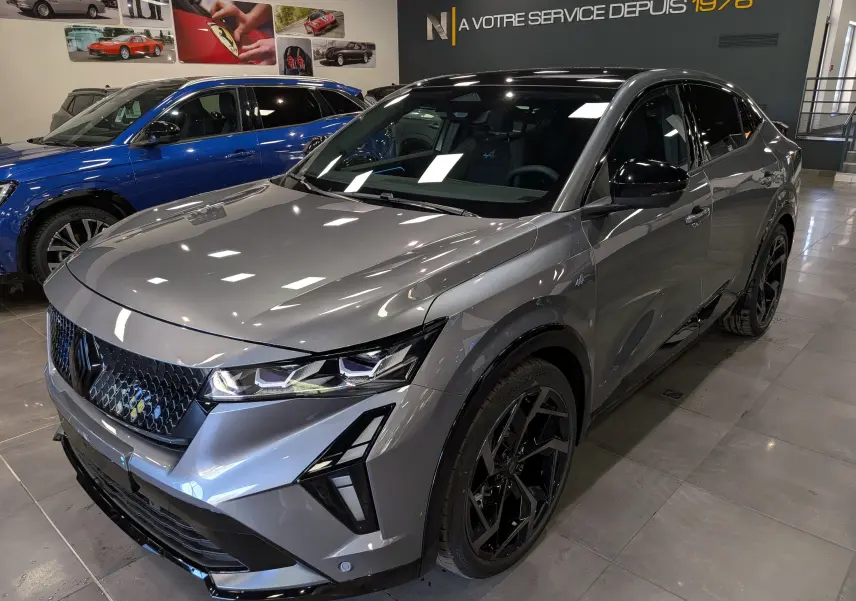 Vue 3/4 avant droit du Renault Rafale gris schiste avec jantes noires et signature lumineuse distinctive en showroom.