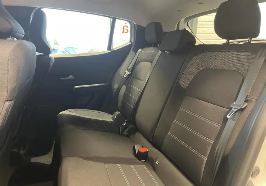 Vue intérieure côté droit des sièges arrière noirs du Dacia Sandero Stepway blanc glacier 2025 avec ceinture de sécurité visible.