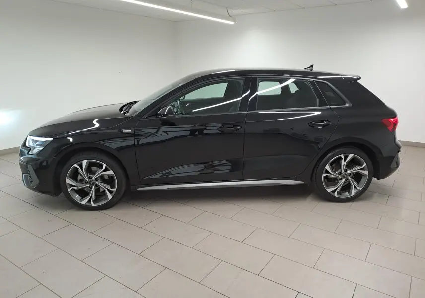 Audi A3 Sportback 35 TFSI S Line noir mythic vue de profil côté gauche en intérieur, jantes alliage distinctives.