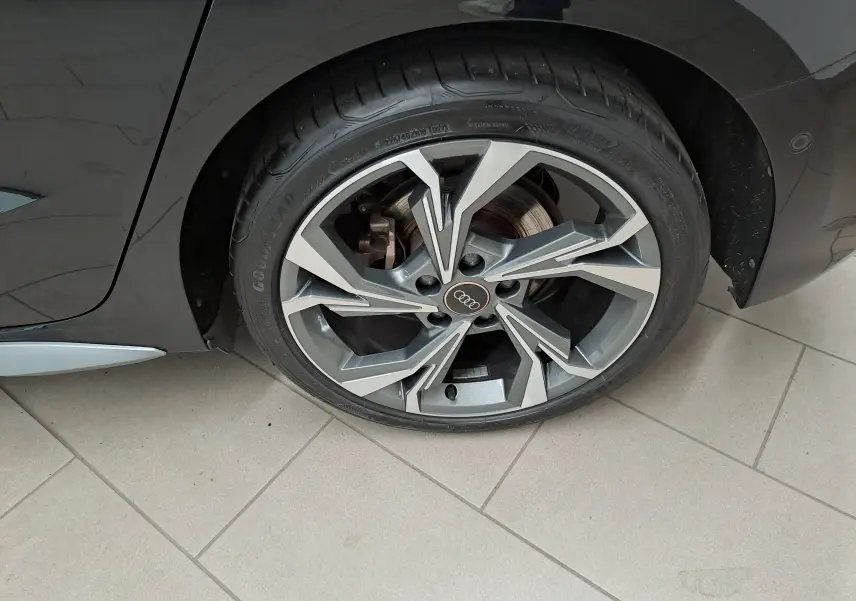 Gros plan sur la roue avant droite de l'Audi A3 Sportback 35 TFSI 150 S Line 2023 en noir mythic, jante alliage à design géométrique.