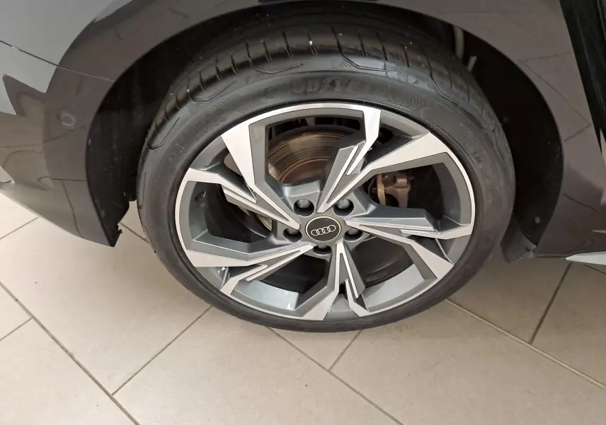 Gros plan sur la roue avant droite de l'Audi A3 Sportback 35 TFSI 150 S Line noire avec jante alliage au design moderne.
