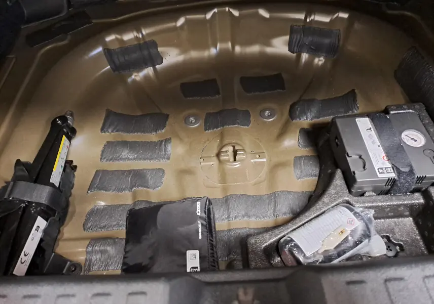 Vue rapprochée de la zone de rangement sous le coffre de l'Audi A3 Sportback 35 TFSI 150 S Line 2023, sans roue de secours.