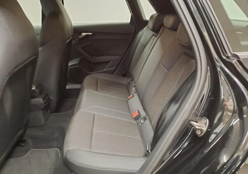 Vue intérieure côté droit des sièges arrière en tissu et cuir noir d’un Audi A3 Sportback 35 TFSI S Line 2023 Noir Mythic.