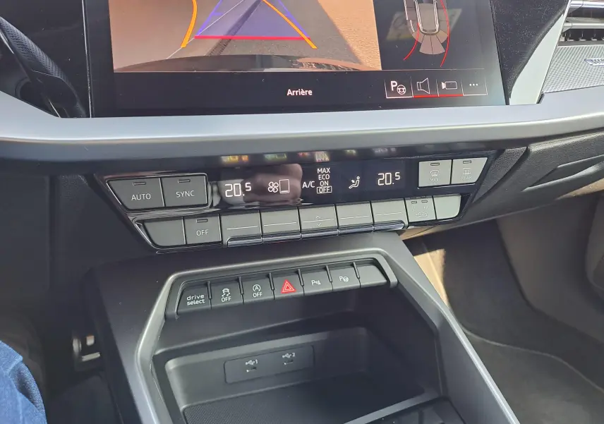 Vue rapprochée de la console centrale de l’Audi A3 Sportback 2023 avec commandes climatisation et écran multimédia.
