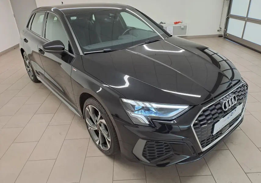 Audi A3 Sportback 35 TFSI S Line noir mythic vue 3/4 avant droit, avec calandre hexagonale et phares LED distinctifs.