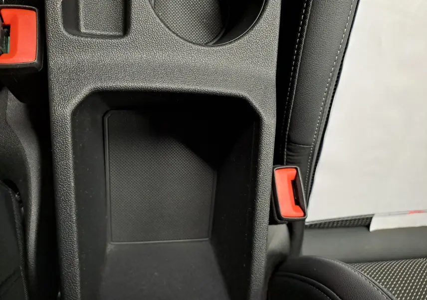 Gros plan intérieur sur le rangement central et la ceinture de sécurité rouge de l'Audi A3 Sportback Noir Mythic 2023.
