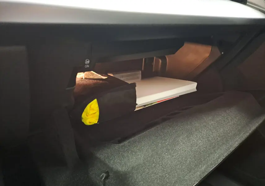 Intérieur de la boîte à gants ouverte de l'Audi A3 Sportback 35 TFSI 2023 avec éclairage et rangement visible.