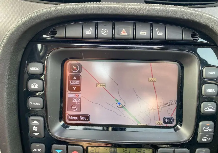 Écran tactile du système de navigation de la Jaguar XJ noire, vue rapprochée du tableau de bord central.