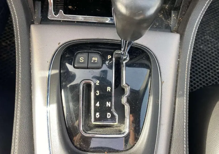 Gros plan sur la console centrale noire de la Jaguar XJ 2006, mettant en valeur le levier de vitesse automatique chromé.