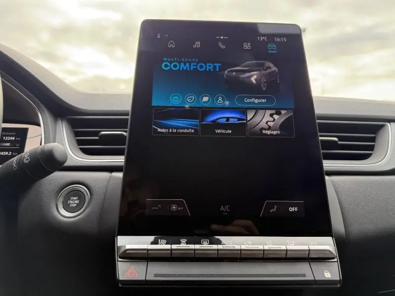 Écran tactile central du tableau de bord du Renault Captur 2025, affichant le mode confort, avec bouton start/stop visible à gauche.