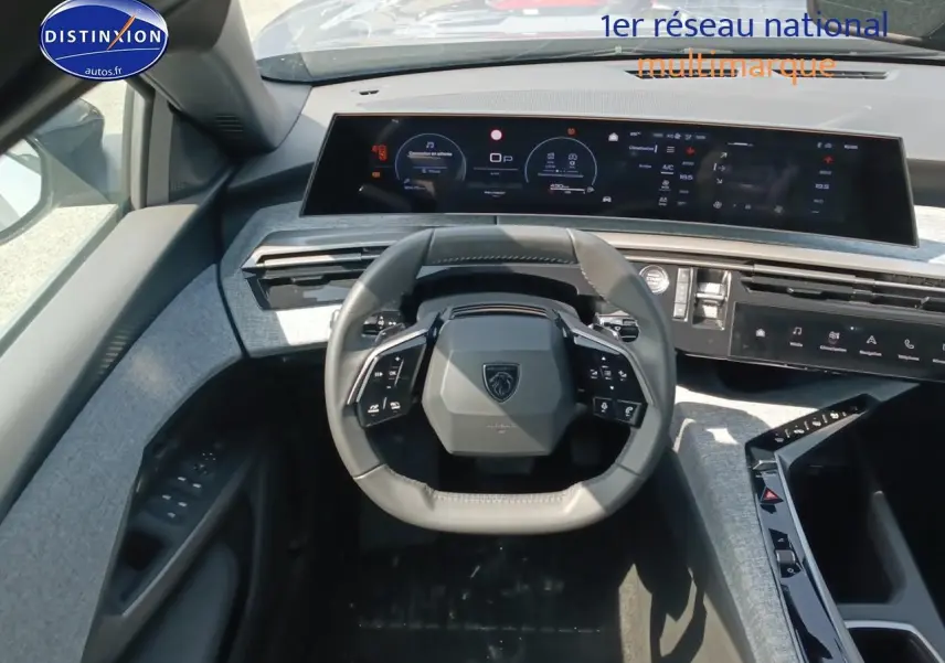 Vue intérieure centrée sur le volant cuir multifonction et le tableau de bord numérique du Peugeot 5008 gris Artense 2025.