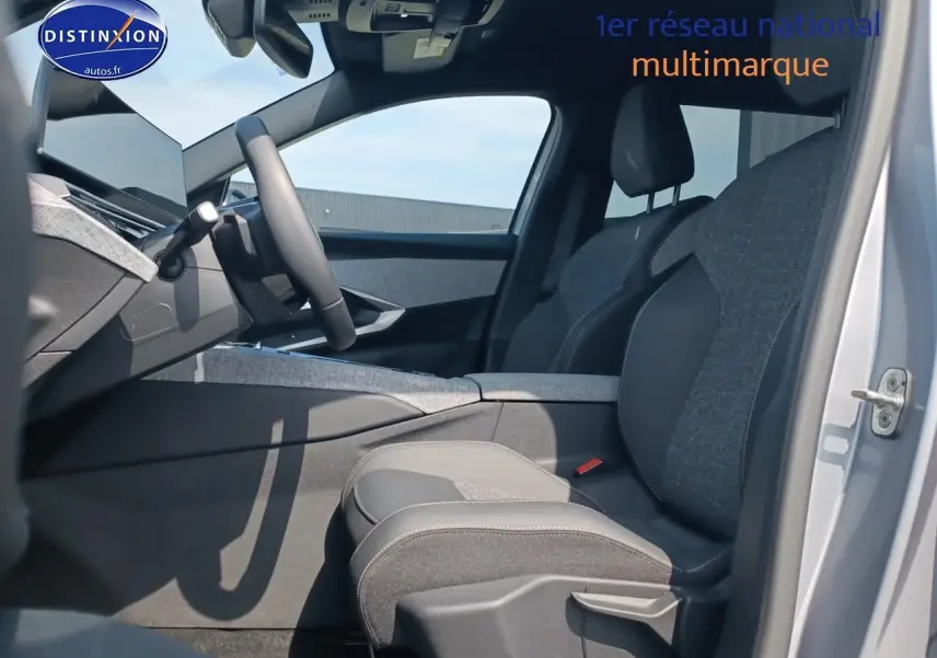 Vue intérieure côté conducteur du Peugeot 5008 gris artense, mettant en valeur les sièges avant en tissu et cuir et le tableau de bord moderne.