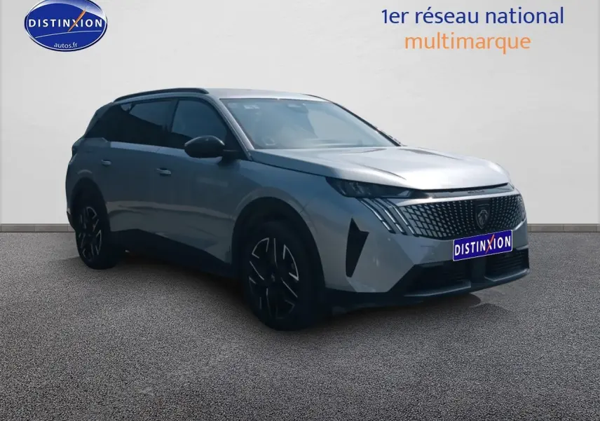 Peugeot 5008 Hybrid gris artense en 3/4 avant droit, avec calandre distinctive et jantes noires.