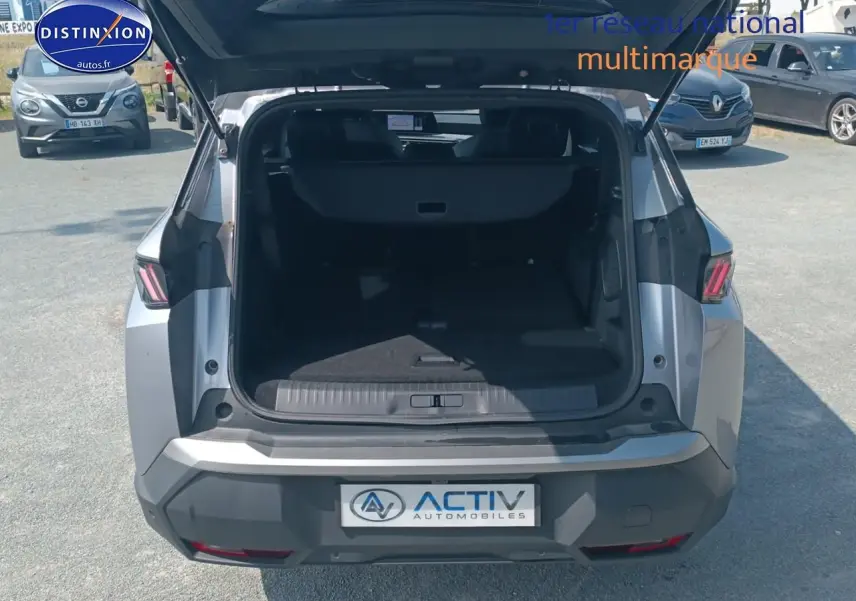 Vue arrière du Peugeot 5008 gris artense 2025 avec coffre ouvert et hayon relevé en extérieur.