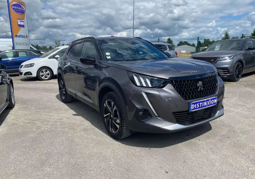 Peugeot 2008 gris foncé en 3/4 avant droit, avec jantes alliage bi-tons et signature lumineuse LED distinctive.